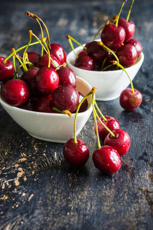 Organic food concept ripe red sweet cherries on dark wooden tableの写真素材