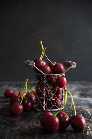 Organic food concept ripe red sweet cherries on dark wooden table