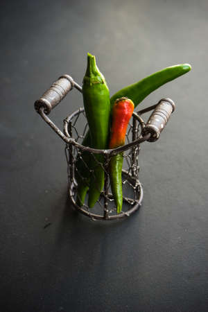 Organic food concept with hot chilli peppers on dark wooden background with copyspaceの写真素材