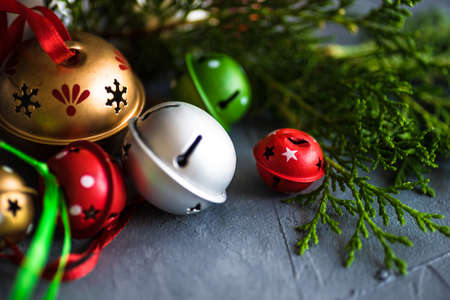 Christmas frame with christmas tree branches and jingle bells on grey concrete backgroundの写真素材