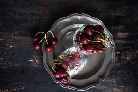Organic food concept ripe red sweet cherries on dark wooden table