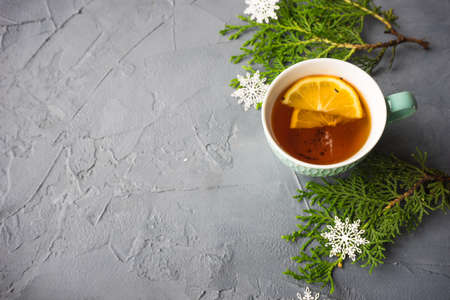 Cup of tea with lemon on rustic concrete background with Christmas decorationの写真素材