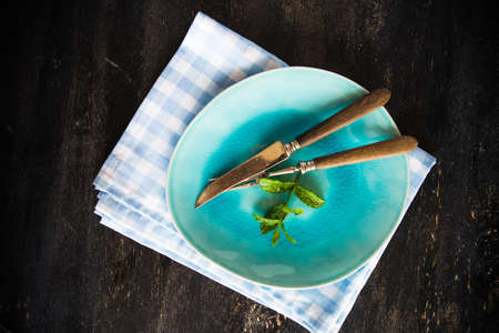 Summertime table setting with fresh mint on dark wooden table with copyspaceの写真素材
