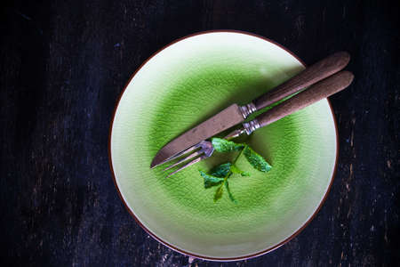 Summertime table setting with fresh mint on dark wooden table with copyspaceの写真素材