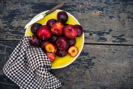 Fresh organic plums  on old rustic wooden tableの写真素材