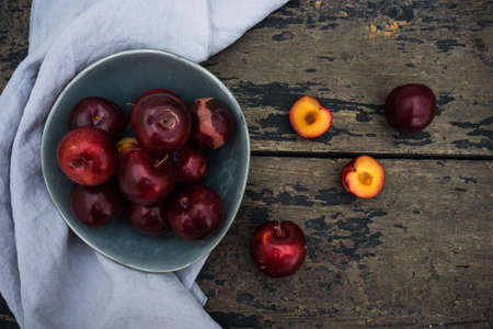 Fresh organic plums  on old rustic wooden tableの写真素材
