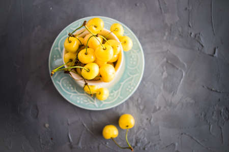 Organic food concept ripe yellow sweet cherries on rustic wooden table with copyspaceの写真素材