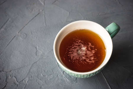 Cup of tea with lemon on rustic concrete background with Christmas decorationの写真素材