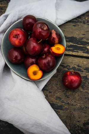 Fresh organic plums  on old rustic wooden tableの写真素材
