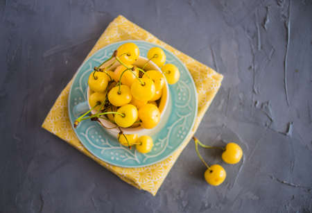 Organic food concept ripe yellow sweet cherries on rustic wooden table with copyspaceの写真素材