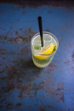 Homemade lemonade with fresh organic citrus fruits and  ice on old rustic metal table with copyspaceの写真素材