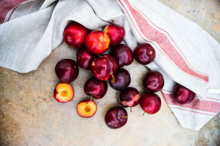 Fresh organic plums  on old rustic wooden tableの写真素材