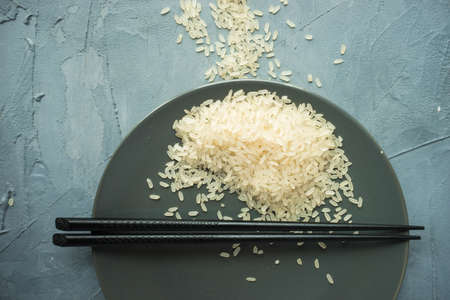 Porcelain plate and rice on grey concrete table with copyspaceの写真素材