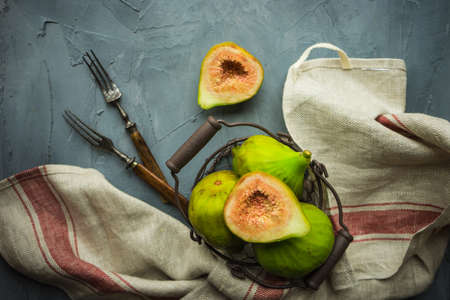 Organic fig tree fruits on the vintage plate on concrete background with copyspace