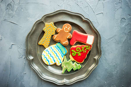 Festive gingerbread cookies for Christmas holiday celebration on ceramic plate on concrete background with copyspaceの写真素材