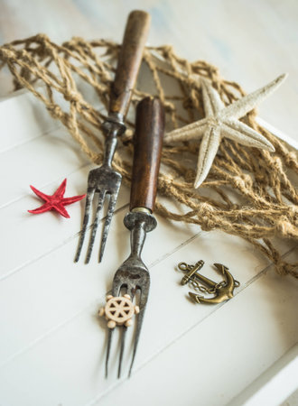Summer vacation marine table setting with rustic plates and silverware on wooden background with copyspaceの写真素材