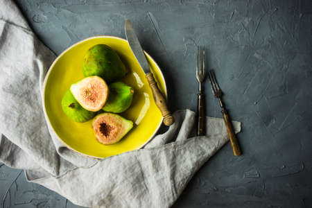 Organic fig tree fruits on the vintage plate on concrete background with copyspaceの写真素材