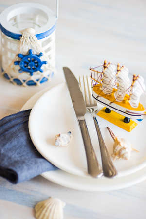 Summer vacation marine table setting with rustic plates and silverware on wooden background with copyspaceの写真素材