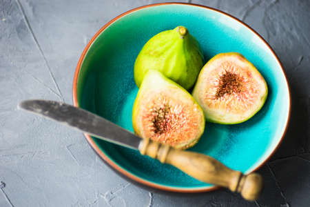 Organic fig tree fruits on the vintage plate on concrete background with copyspaceの写真素材