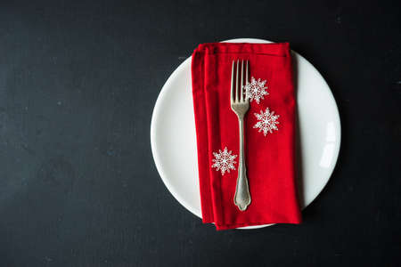 Festive table setting for Christmas dinner on dark rustic table with copyspace