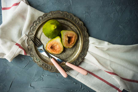 Organic fig tree fruits on the vintage plate on concrete background with copyspaceの写真素材