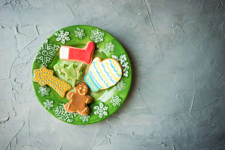 Festive gingerbread cookies for Christmas holiday celebration on ceramic plate on concrete background with copyspaceの写真素材