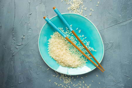 Porcelain plate and rice on grey concrete table with copyspaceの写真素材