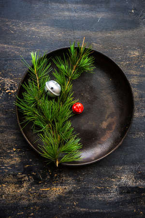Table setting for festive Christmas dinner on dark wooden table with vintage plates and silverwareの写真素材
