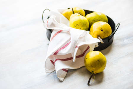 Organic pear fruits on the vintage plate on wooden background with copyspace