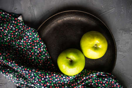 Healthy food concept with ripe organic apples and vintage flatware on concrete background with copyspaceの写真素材