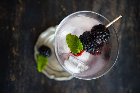 Detox lemonade with fresh organic blackberries and lemon on dark wooden table with copyspaceの写真素材