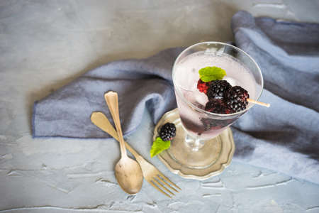 Detox lemonade with fresh organic blackberries and lemon on dark wooden table with copyspaceの写真素材