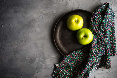 Healthy food concept with ripe organic apples and vintage flatware on concrete background with copyspaceの写真素材