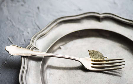 Autumnal table setting with golden autumn leave on concrete backgroundの写真素材