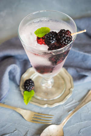 Detox lemonade with fresh organic blackberries and lemon on dark wooden table with copyspaceの写真素材