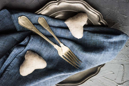 Rustic table setting with heart shaped decoration and vintage flatware on grey concrete background with copyspaceの写真素材