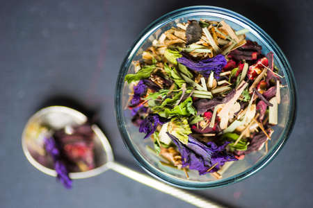 Different types of tea, green tea, peony and ginger tea, rose bud and wild flowers tea on dark wooden background with copyspaceの写真素材