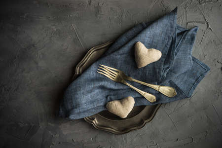 Rustic table setting with heart shaped decoration and vintage flatware on grey concrete background with copyspaceの写真素材