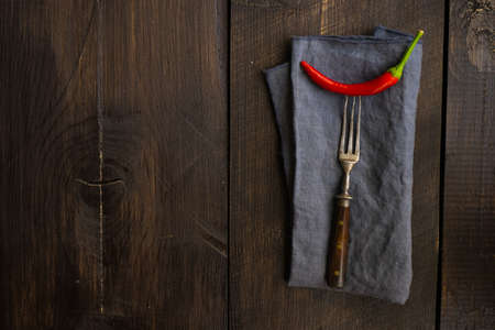 Organic chilli peppers on a pan on dark wooden backgroundの写真素材