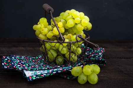 Fresh organic autumnal grapes on rustic plates on old wooden table with copyspaceの写真素材