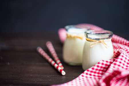 Vintage bottles with homemade yogurt with chia seeds, mint and plum fruits