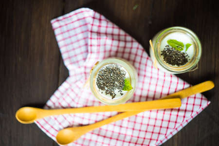 Vintage bottles with homemade yogurt with chia seeds, mint and plum fruitsの写真素材
