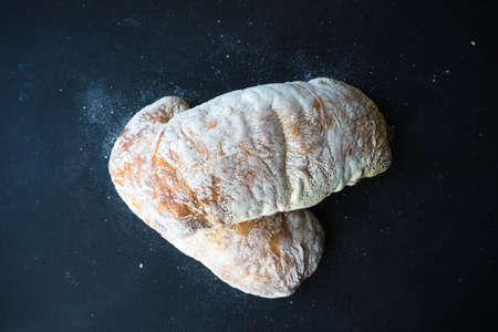Fresh baked italian bread - ciabatta  on rustic table with napkin