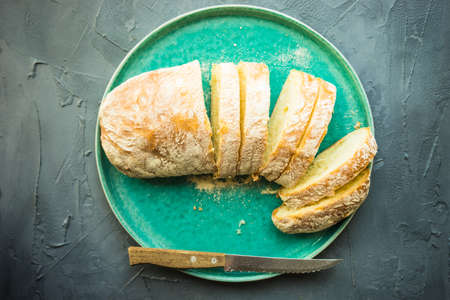 Fresh baked italian bread - ciabatta  on rustic table with napkin