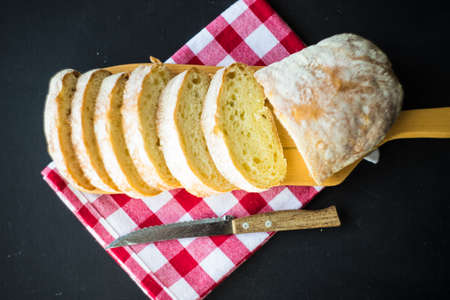 Fresh baked italian bread - ciabatta  on rustic table with napkin