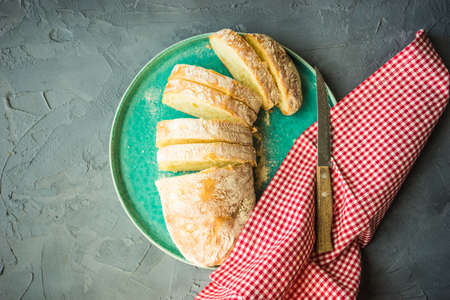 Fresh baked italian bread - ciabatta  on rustic table with napkin