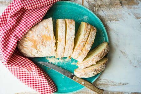 Fresh baked italian bread - ciabatta  on rustic table with napkinの写真素材