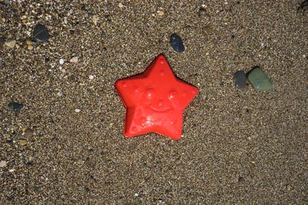 Red kids beach toy on the sea coast as a summertime relax conceptの写真素材