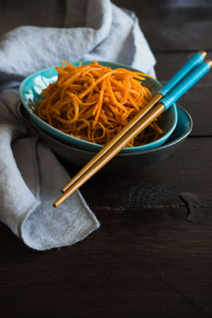 Organic spicy carrot salad on rustic table with copyspace as an organic food conceptの写真素材