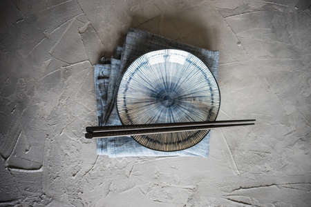 pair of chopsticks and plate on rustic wooden backgroundの写真素材